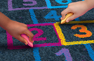 Students draw hopscotch pattern with chalk